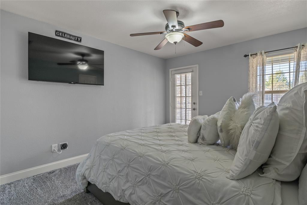 8342 Timberbrook Lane Dallas, TX 75249 - Photo 19 of 25 a bedroom with a large bed and a flat screen tv