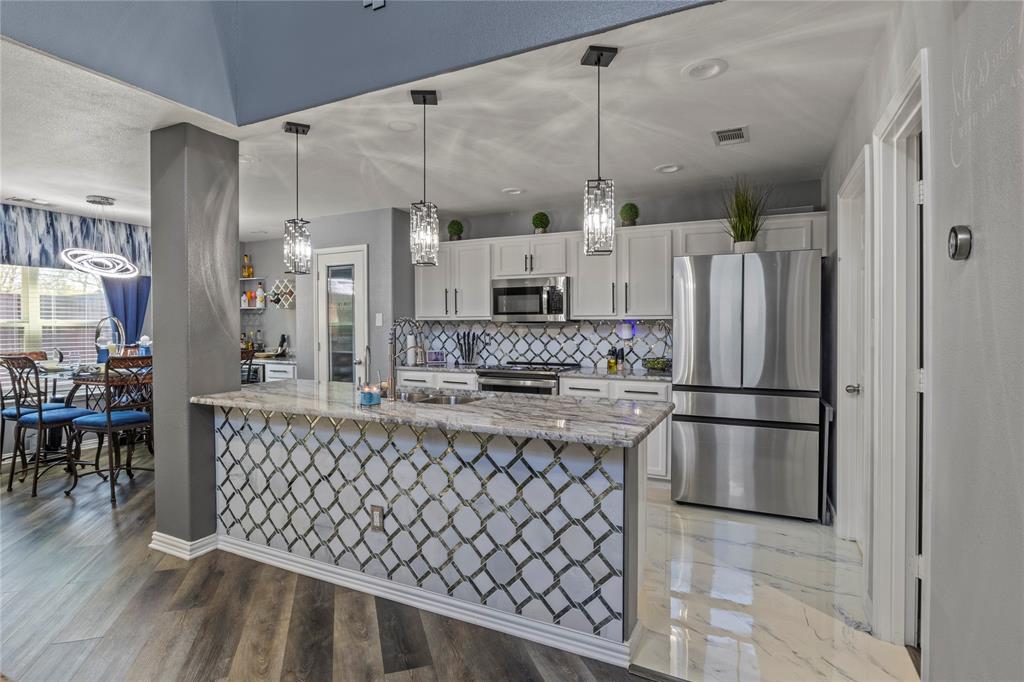 8342 Timberbrook Lane Dallas, TX 75249 - Photo 7 of 25 a kitchen with stainless steel appliances granite countertop a refrigerator and a stove