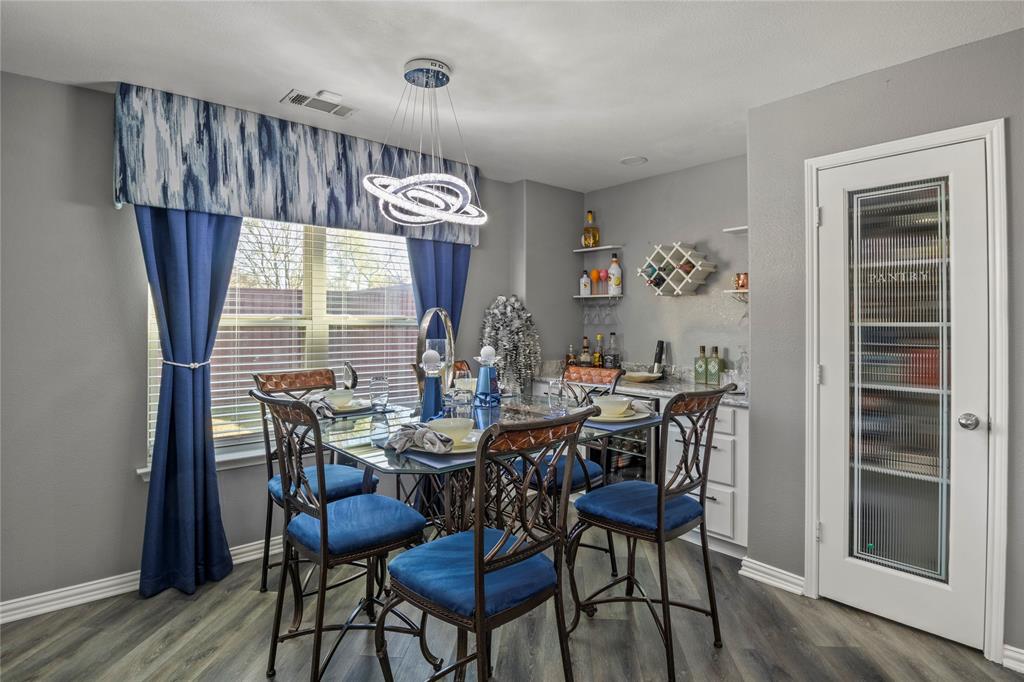 8342 Timberbrook Lane Dallas, TX 75249 - Photo 9 of 25 a view of a dining room with furniture and wooden floor