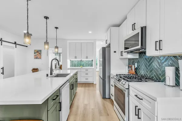 a kitchen with stainless steel appliances a sink stove and refrigerator