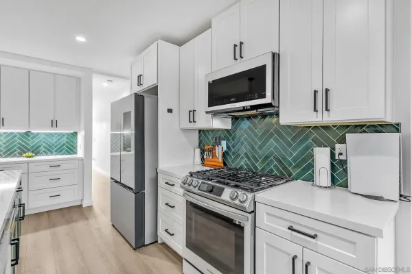 a kitchen with white cabinets and stainless steel appliances