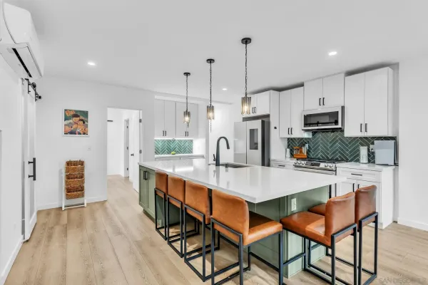 a living room with furniture a wooden floor and a kitchen view