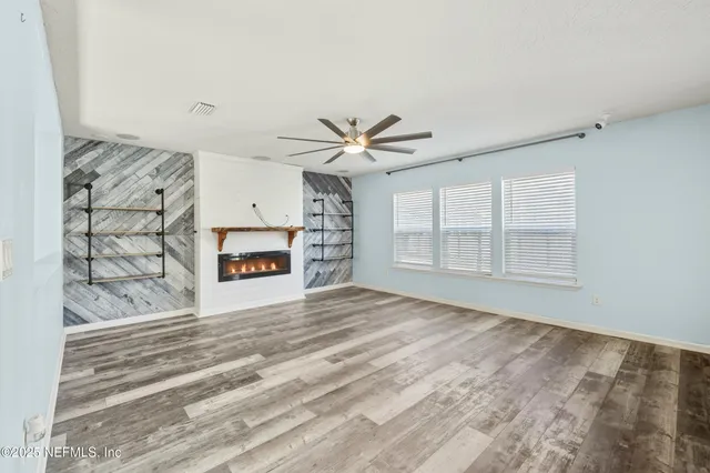 a view of a livingroom with a ceiling fan and window