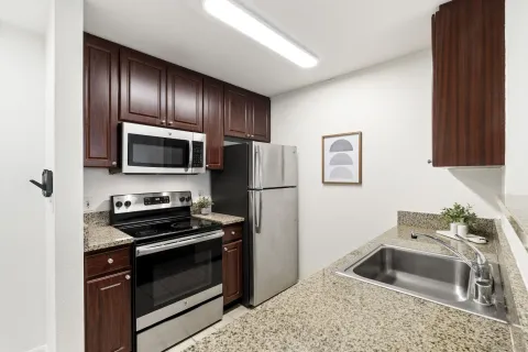 a kitchen with granite countertop stainless steel appliances and a sink