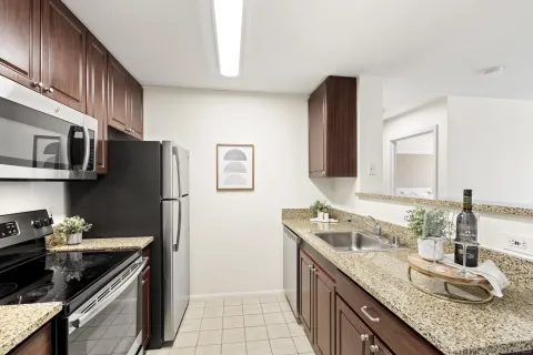 a kitchen with granite countertop a sink stove and refrigerator