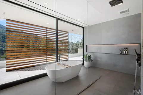 a bathroom with a bathtub and next to a window