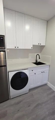 a kitchen with granite countertop white cabinets and stainless steel appliances