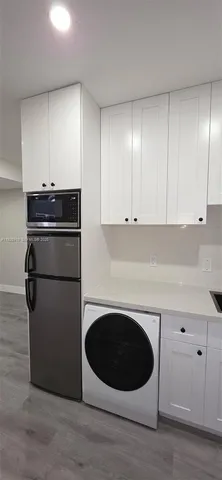 a kitchen with a refrigerator and a stove top oven