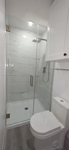 a bathroom with a toilet and a shower