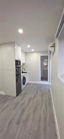 a view of a kitchen with a refrigerator a microwave and a sink