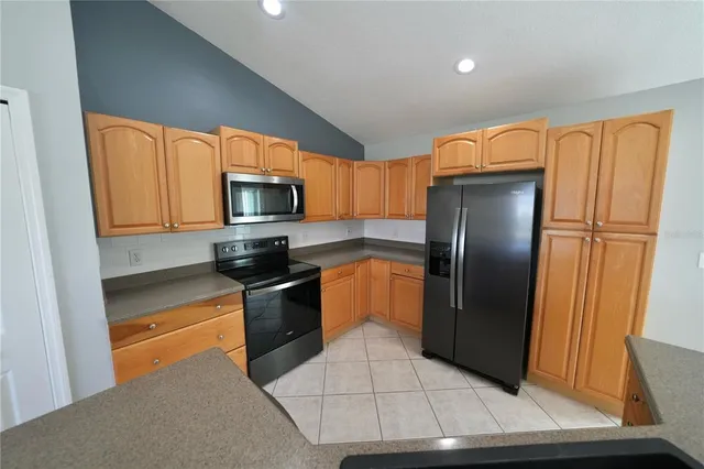 a kitchen with granite countertop a refrigerator and a sink