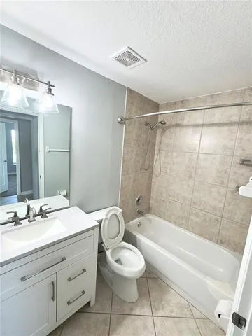 a bathroom with a granite countertop sink toilet a large mirror a bathtub and shower