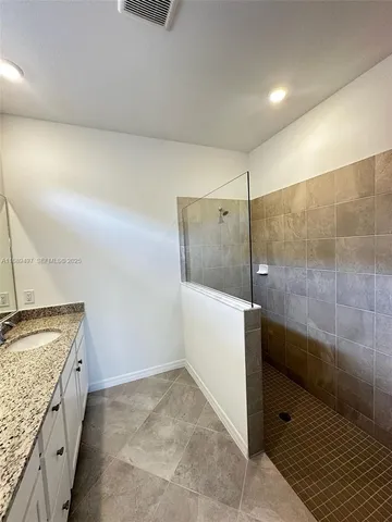 a bathroom with a granite countertop sink a toilet and shower