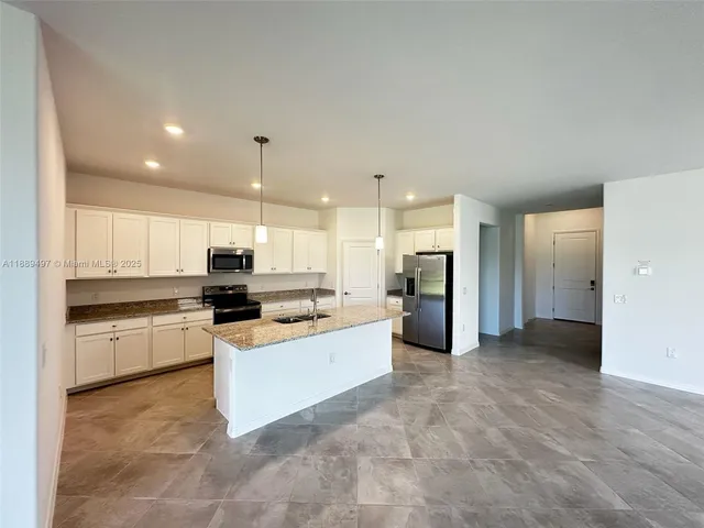 a kitchen with stainless steel appliances a refrigerator sink and cabinets
