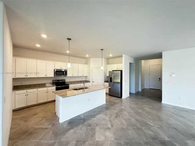 a kitchen with stainless steel appliances kitchen island granite countertop a stove and a refrigerator