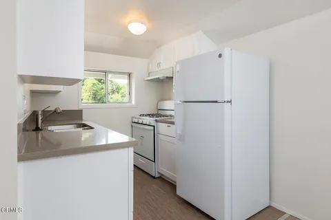 a kitchen with a sink a stove a refrigerator and a window
