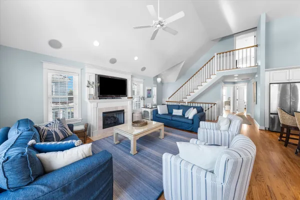 a living room with furniture kitchen view and a wooden floor