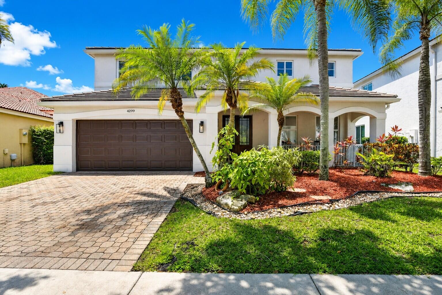 4299 Laurel Ridge Circle Weston, FL 33331 - Photo 1 of 103 a front view of a house with a garden and plants