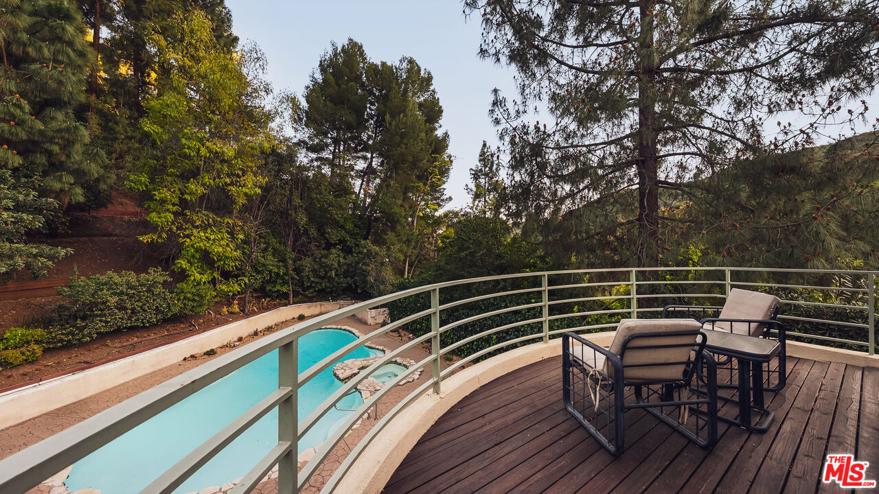 13044 Sky Valley Road Los Angeles, CA 90049 - Photo 13 of 29 a view of a chairs and table on the wooden deck