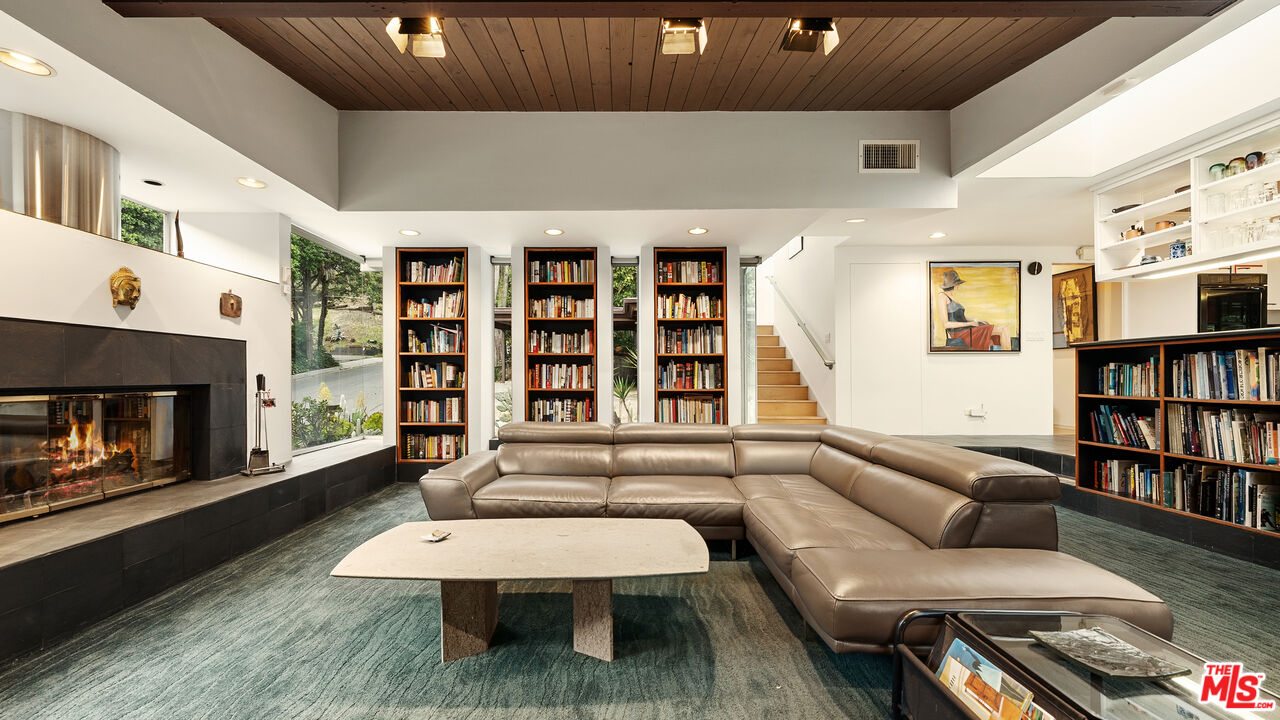 13044 Sky Valley Road Los Angeles, CA 90049 - Photo 17 of 29 a living room with furniture and a book shelf