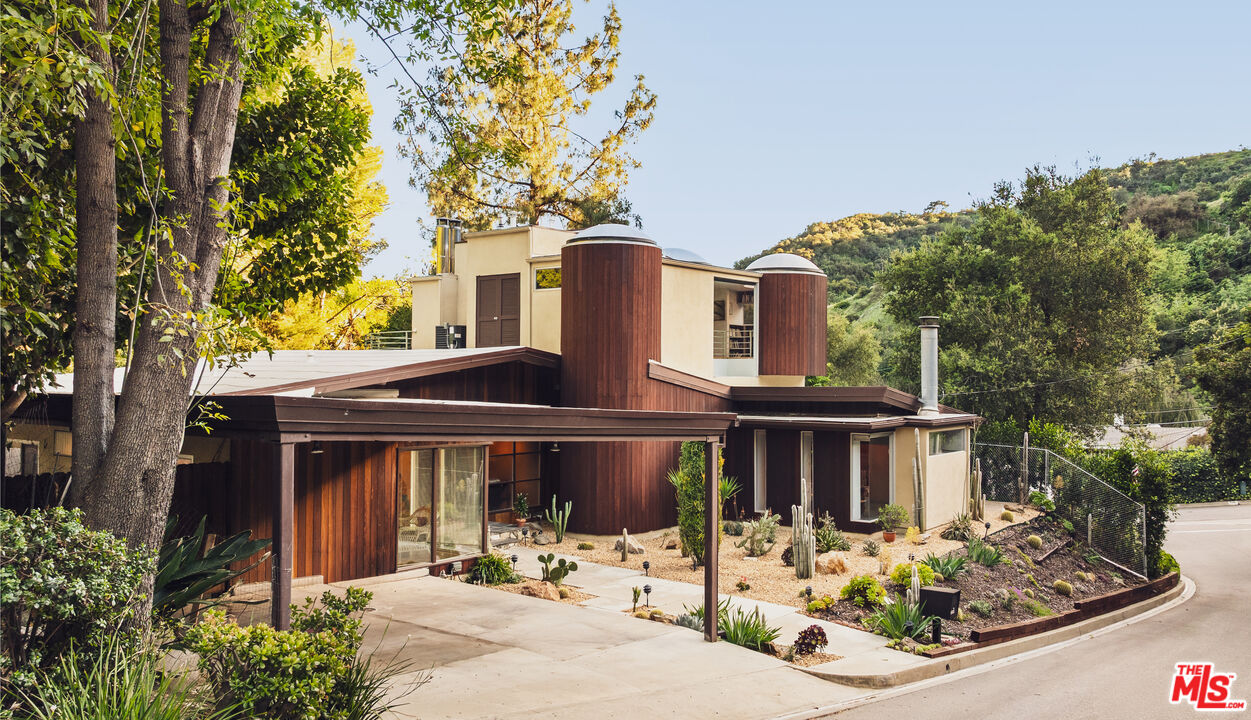 13044 Sky Valley Road Los Angeles, CA 90049 - Photo 29 of 29 a front view of a house with garden and trees