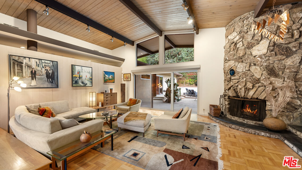 13044 Sky Valley Road Los Angeles, CA 90049 - Photo 4 of 29 a living room with furniture a fireplace and a flat screen tv