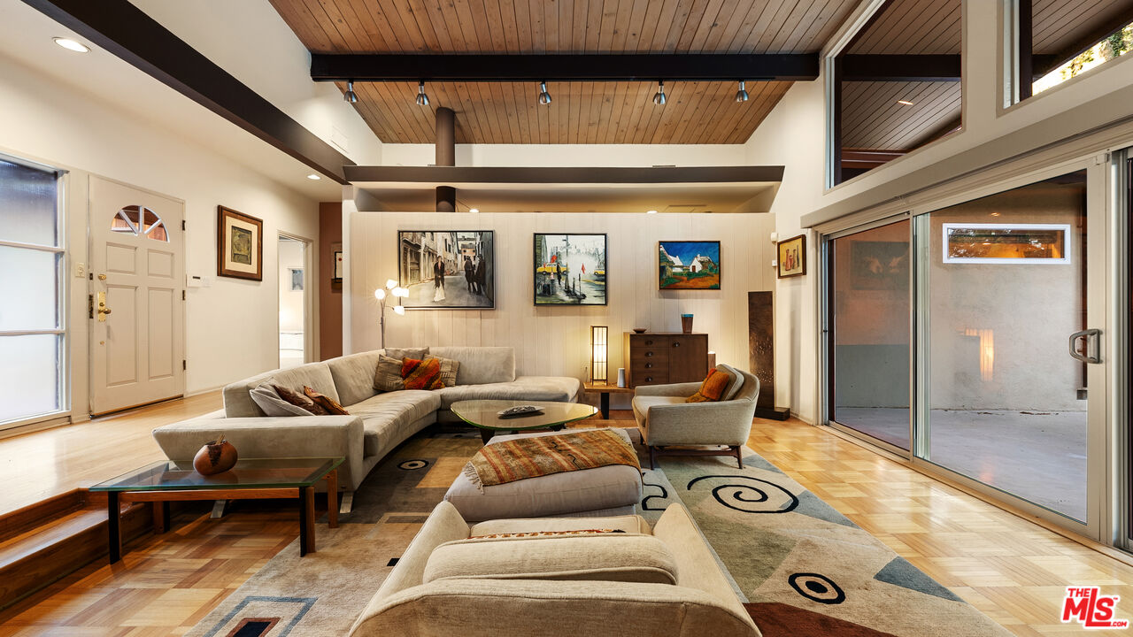 13044 Sky Valley Road Los Angeles, CA 90049 - Photo 5 of 29 a living room with furniture and a floor to ceiling window