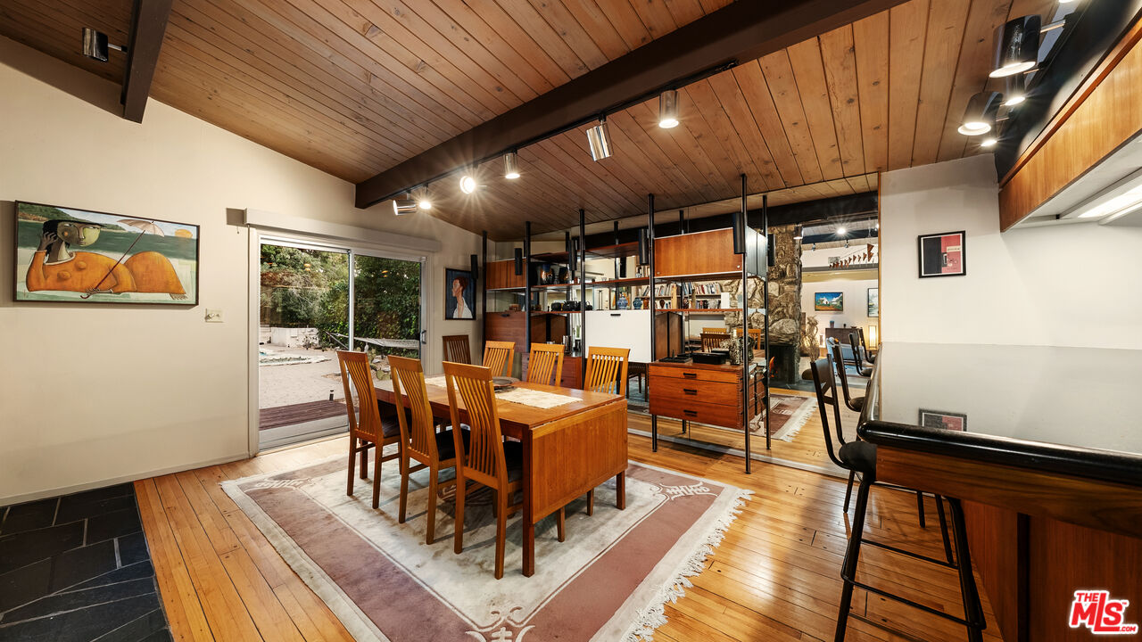 13044 Sky Valley Road Los Angeles, CA 90049 - Photo 7 of 29 a view of a dining room with furniture one side kitchen view and wooden floor