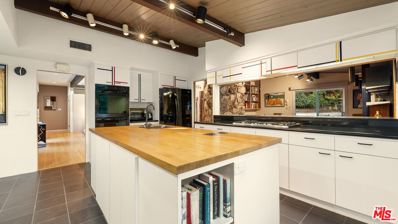 13044 Sky Valley Road Los Angeles, CA 90049 - Photo 8 of 29 a kitchen with stainless steel appliances granite countertop a sink and a refrigerator