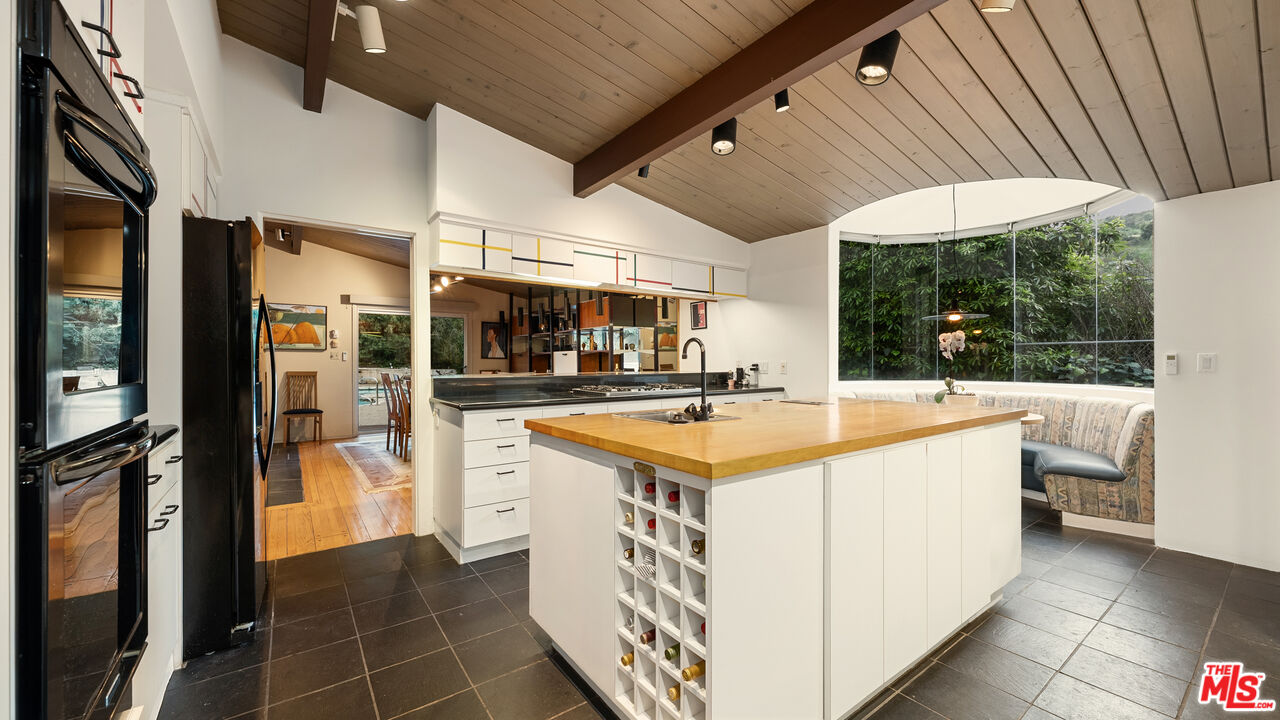 13044 Sky Valley Road Los Angeles, CA 90049 - Photo 9 of 29 a kitchen with stainless steel appliances granite countertop a sink and cabinets