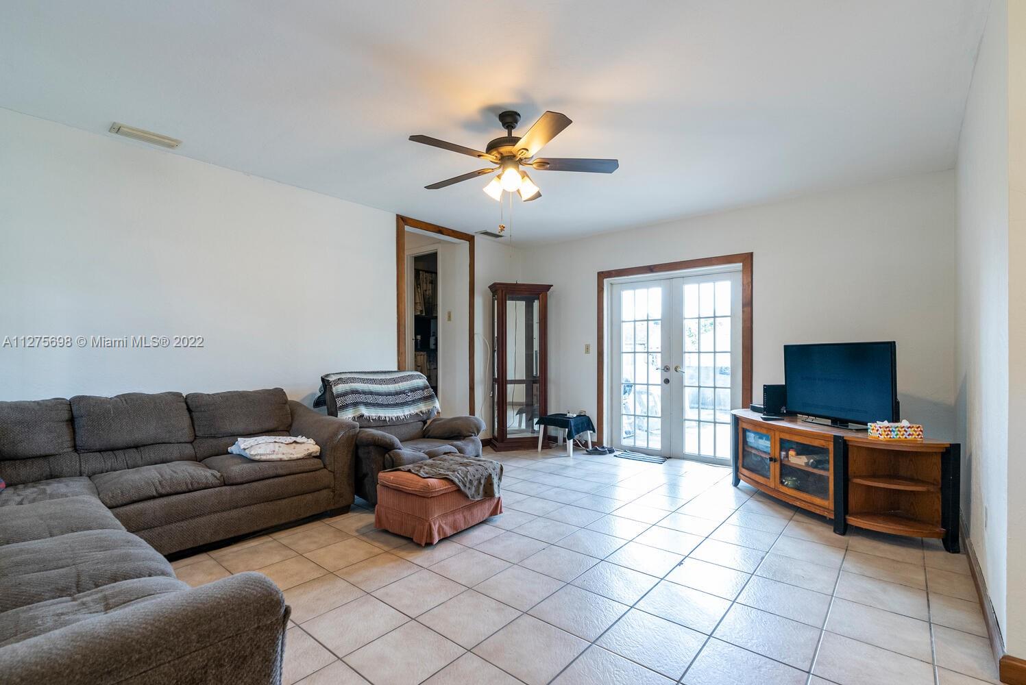 15140 Southwest 296th Street Homestead, FL 33033 - Photo 2 of 13 a living room with furniture and a flat screen tv