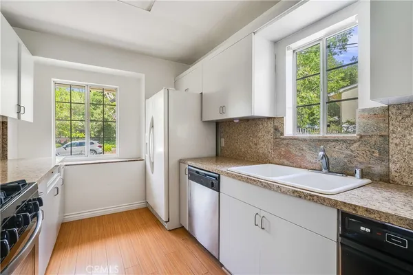 a kitchen with a sink stove and cabinets