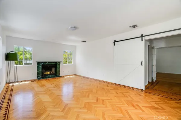 a view of an empty room with a fireplace and a window