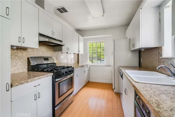 a kitchen with a sink stove top oven and cabinets
