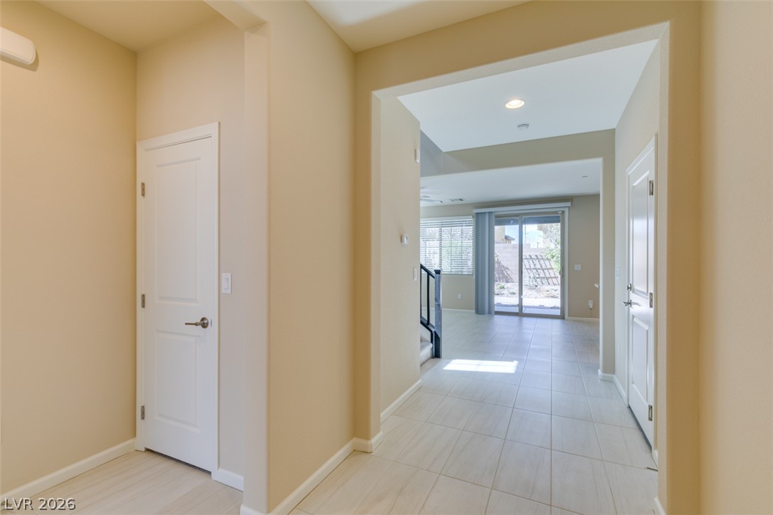 2549 Sable Ridge Street Henderson, NV 89044 - Photo 9 of 48 A sun-filled hallway welcomes you with pristine tiled flooring and recessed lighting.
