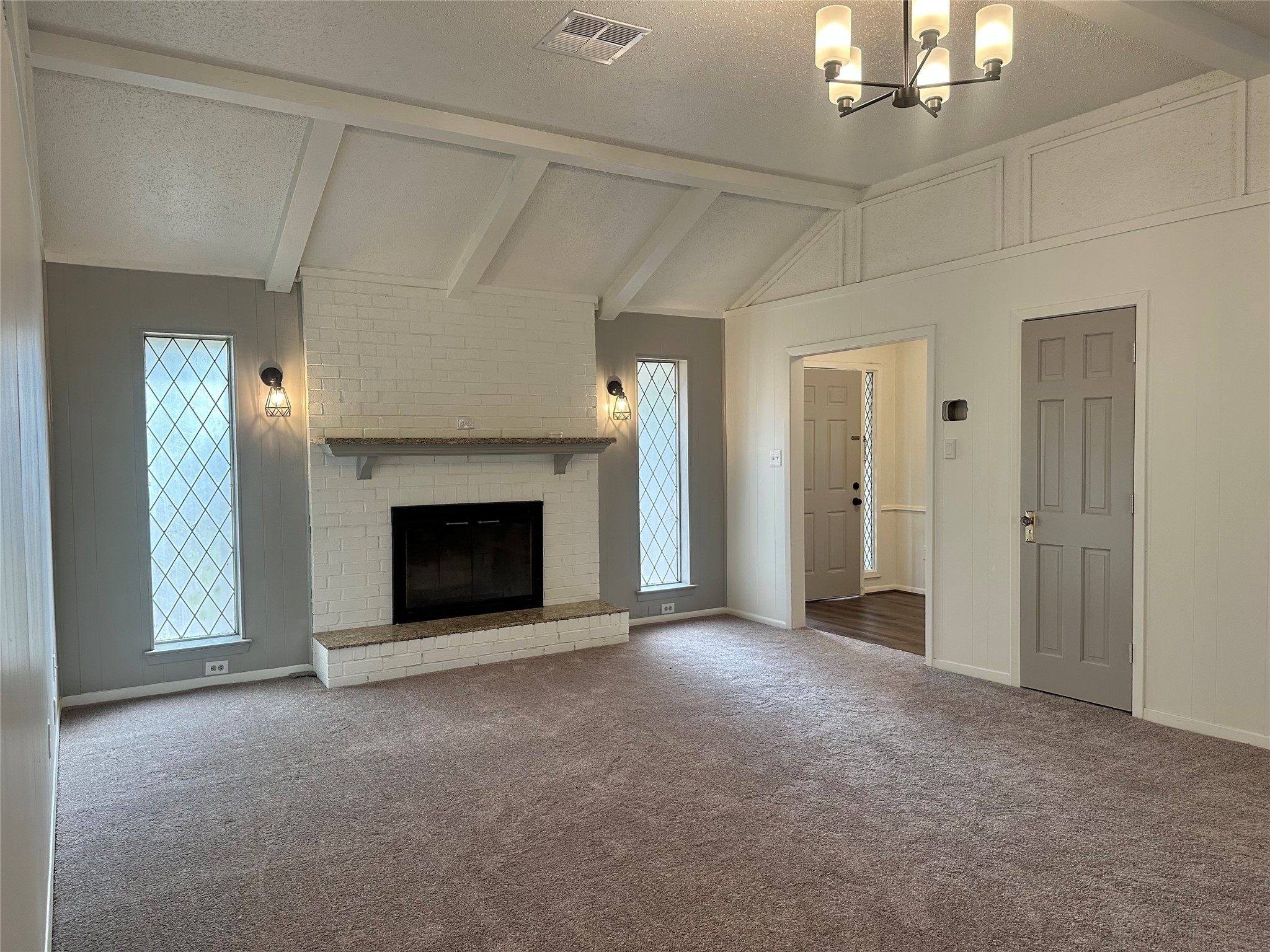 235 Beech Road Conroe, TX 77304 - Photo 2 of 6 a view of a livingroom with a fireplace and chandelier