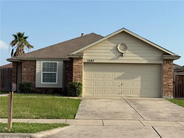 a front view of a house with a garden and yard