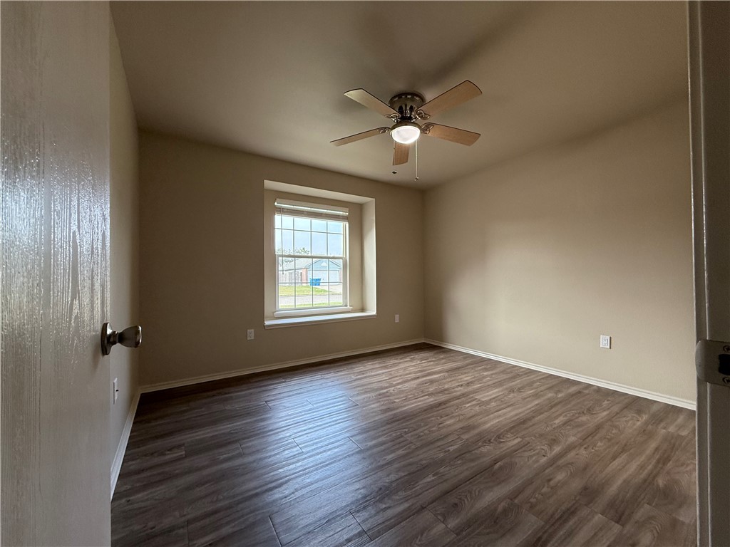 1207 Sacramento Street Portland, TX 78374 - Photo 14 of 22 an empty room with wooden floor fan and windows