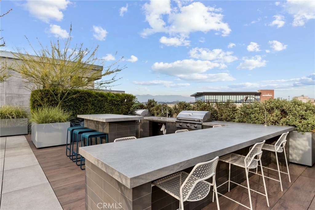 530 South Hewitt Street, Unit 154 Los Angeles, CA 90013 - Photo 24 of 32 a view of a patio with table and chairs with wooden floor and fence