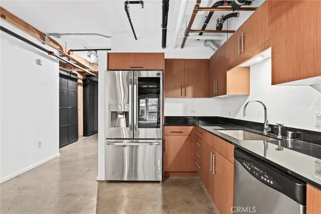 a kitchen with stainless steel appliances granite countertop a sink and a refrigerator