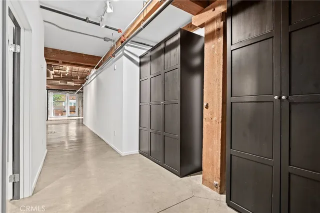 a view of a refrigerator in kitchen and an empty room