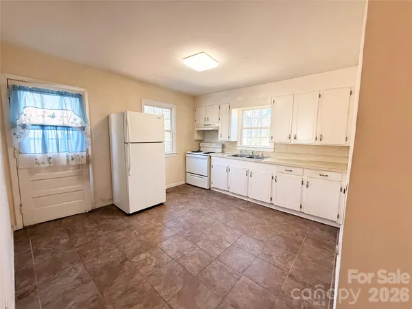 a kitchen with white cabinets and white appliances