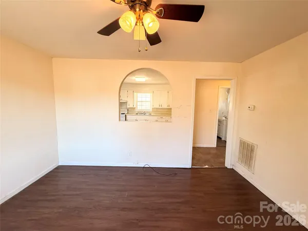 a view of a room with wooden floor and ceiling fan