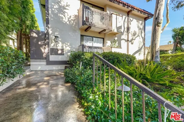 a view of a house with brick walls and plants