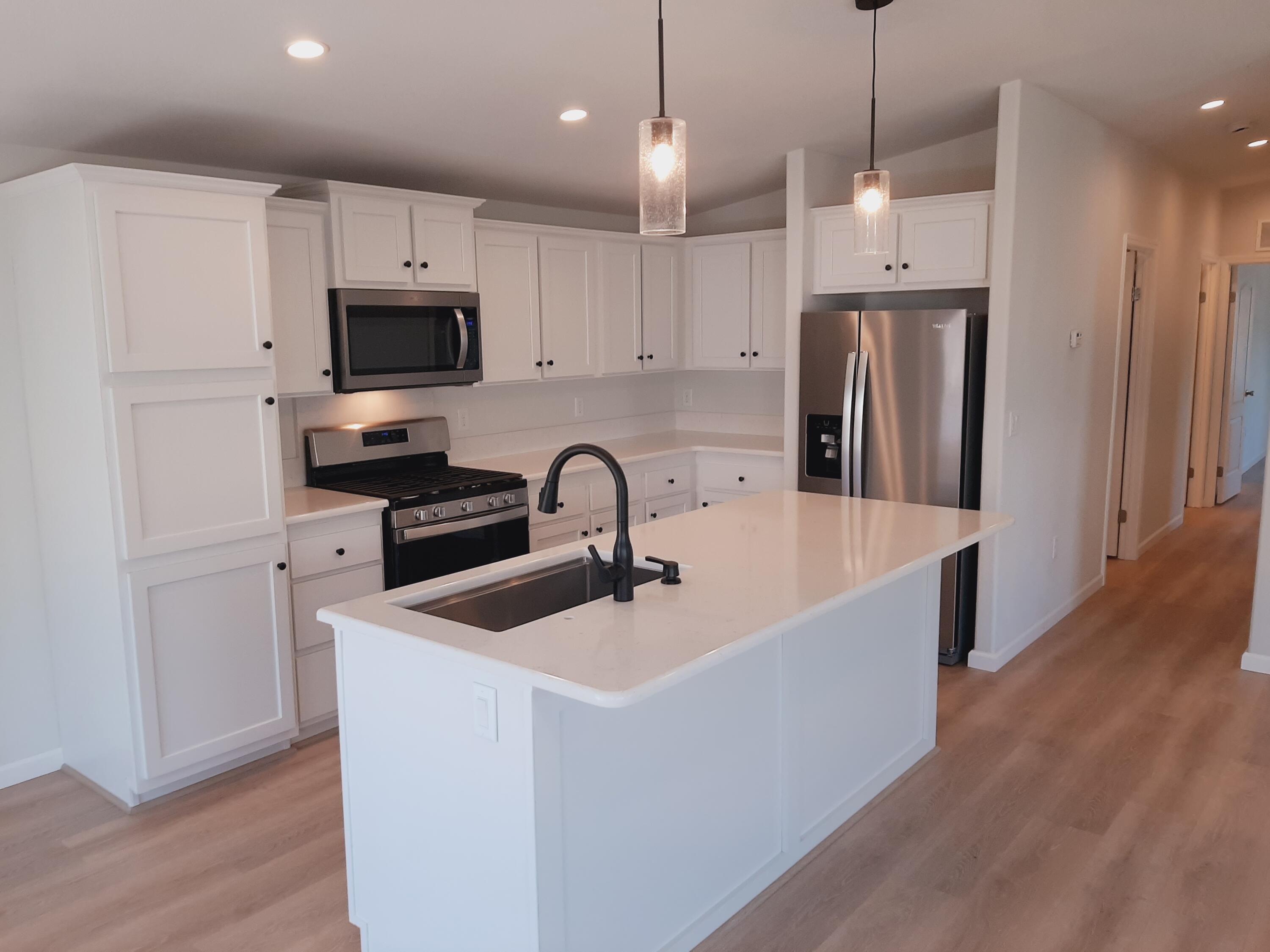 333 Old Mill Road, Unit 52 Santa Barbara, CA 93110 - Photo 6 of 29 a kitchen with stainless steel appliances a refrigerator a sink a stove a microwave and wooden floor