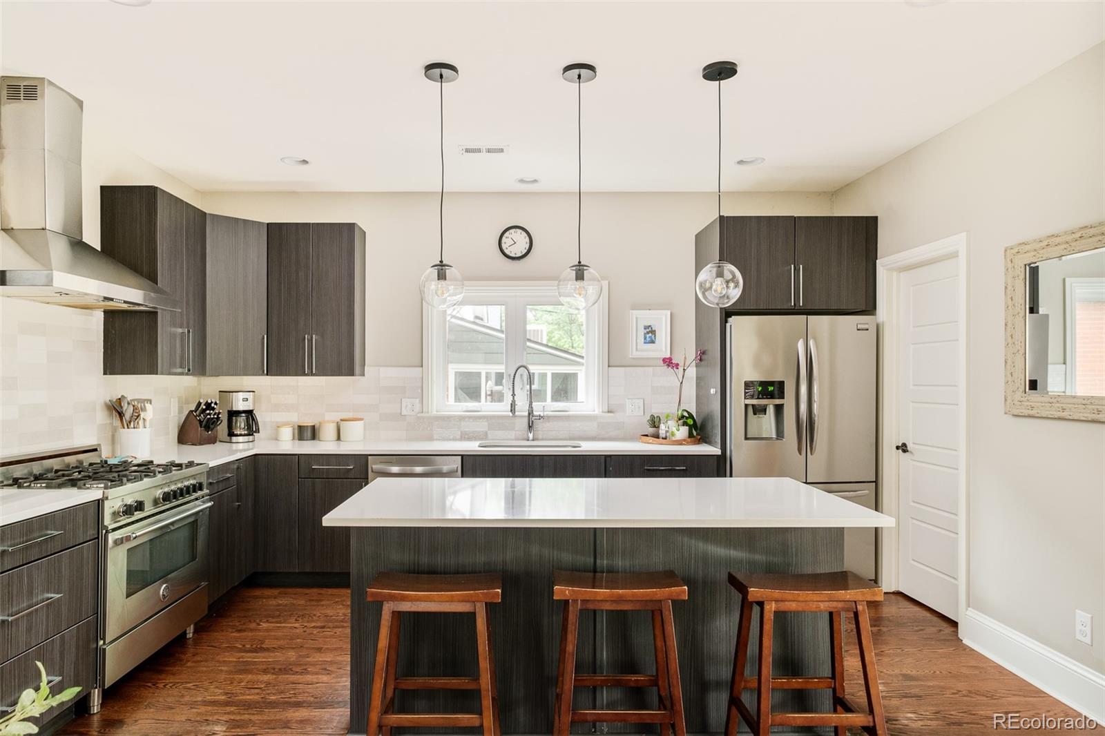 3864 Osceola Street Denver, CO 80212 - Photo 16 of 43 a kitchen with a table chairs stove and cabinets