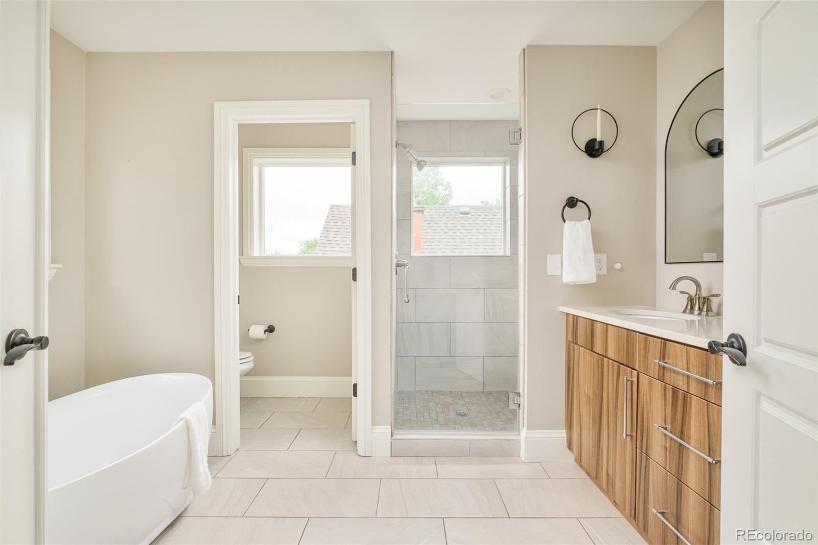 3864 Osceola Street Denver, CO 80212 - Photo 26 of 43 a bathroom with a shower a sink and a mirror