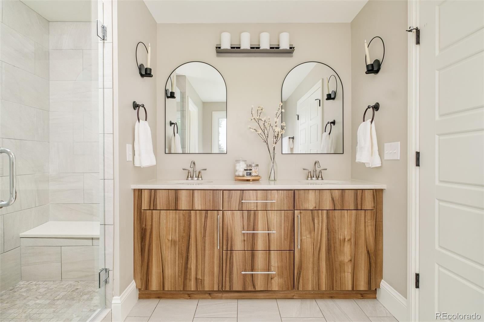 3864 Osceola Street Denver, CO 80212 - Photo 27 of 43 a bathroom with mirror a sink and glass door