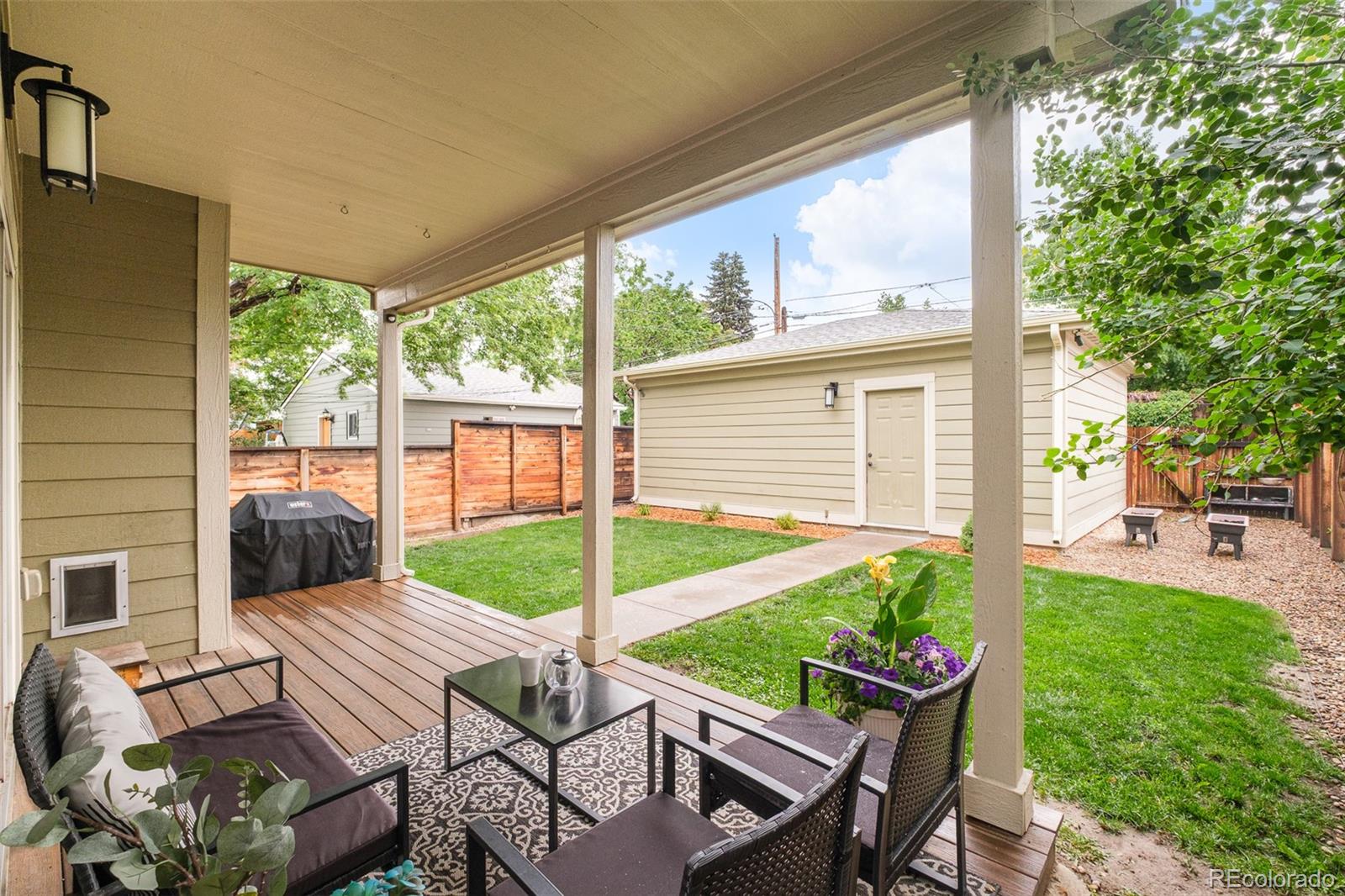 3864 Osceola Street Denver, CO 80212 - Photo 40 of 43 a view of a patio with table and chairs potted plants with wooden floor