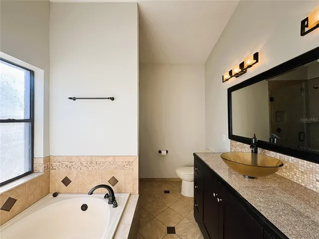 a bathroom with a granite countertop sink a mirror and shower